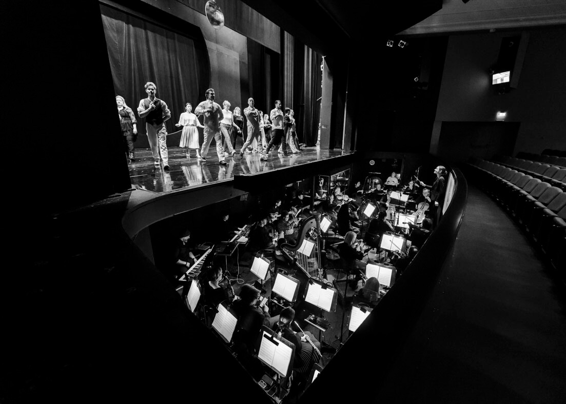 Orchestergraben mit Musikern und Darstellern auf der Bühne während einer Probe für das Kammerkonzert Nr. 5 im Theater Lüneburg.