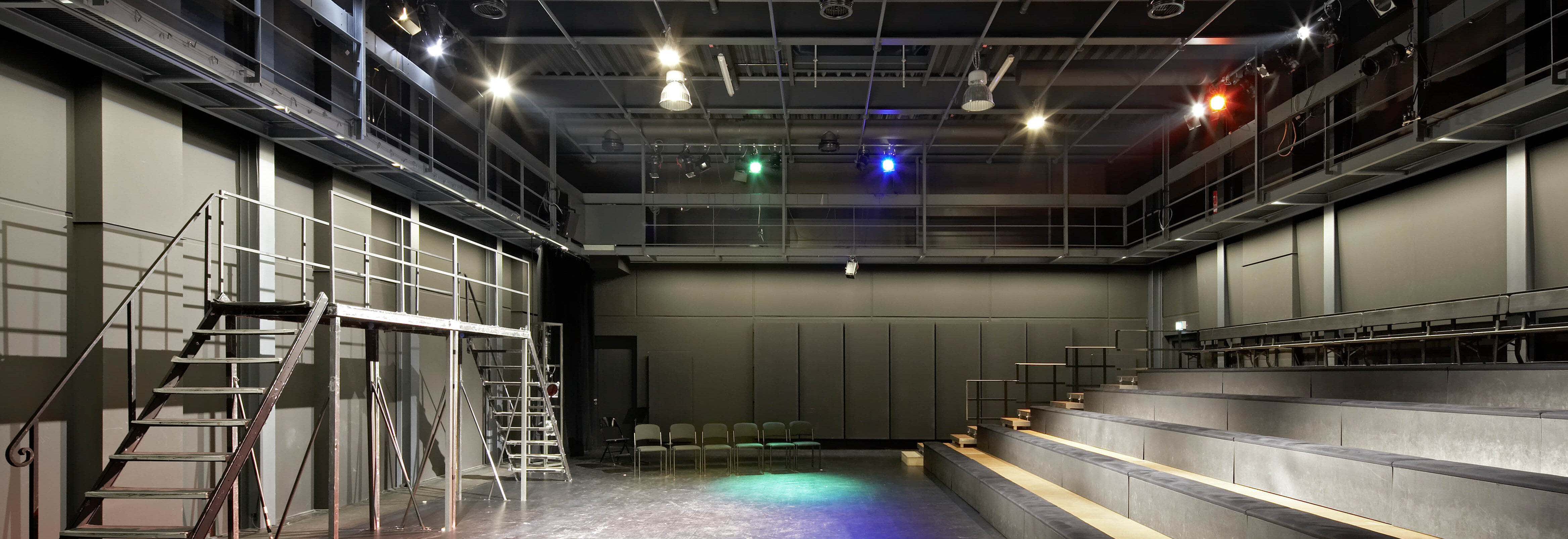 Innenansicht eines modernen Theatersaals mit Beleuchtung und Sitzplätzen